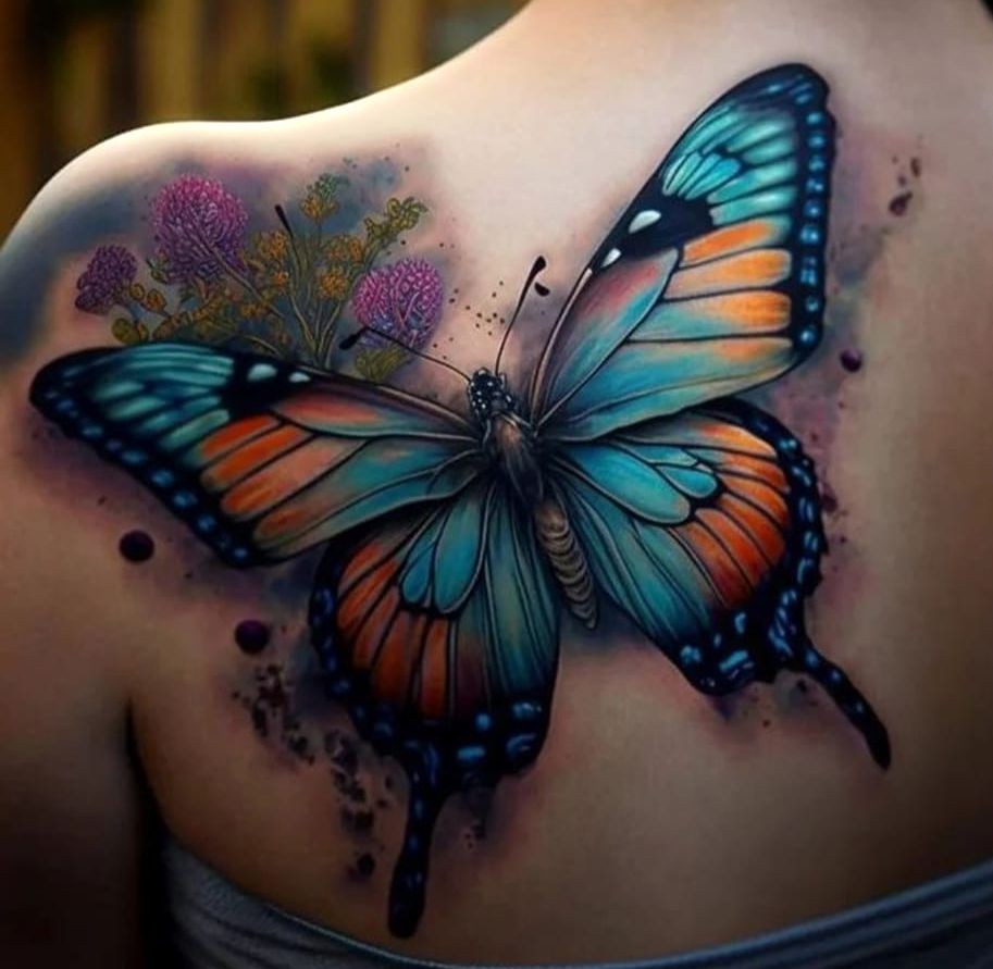 colorful butterfly tattooed on the shoulder blade