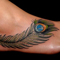 peacock feather tattoo on leg on black background